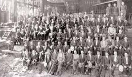 The blast furnace crew of the Anyox smelter in 1917, some eighty men seated and standing in rows inside the smelter building