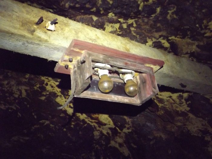 A wooden lamp box fixed to a timber in the Hidden Creek mine at Anyox, BC, two old bulbs still in their sockets