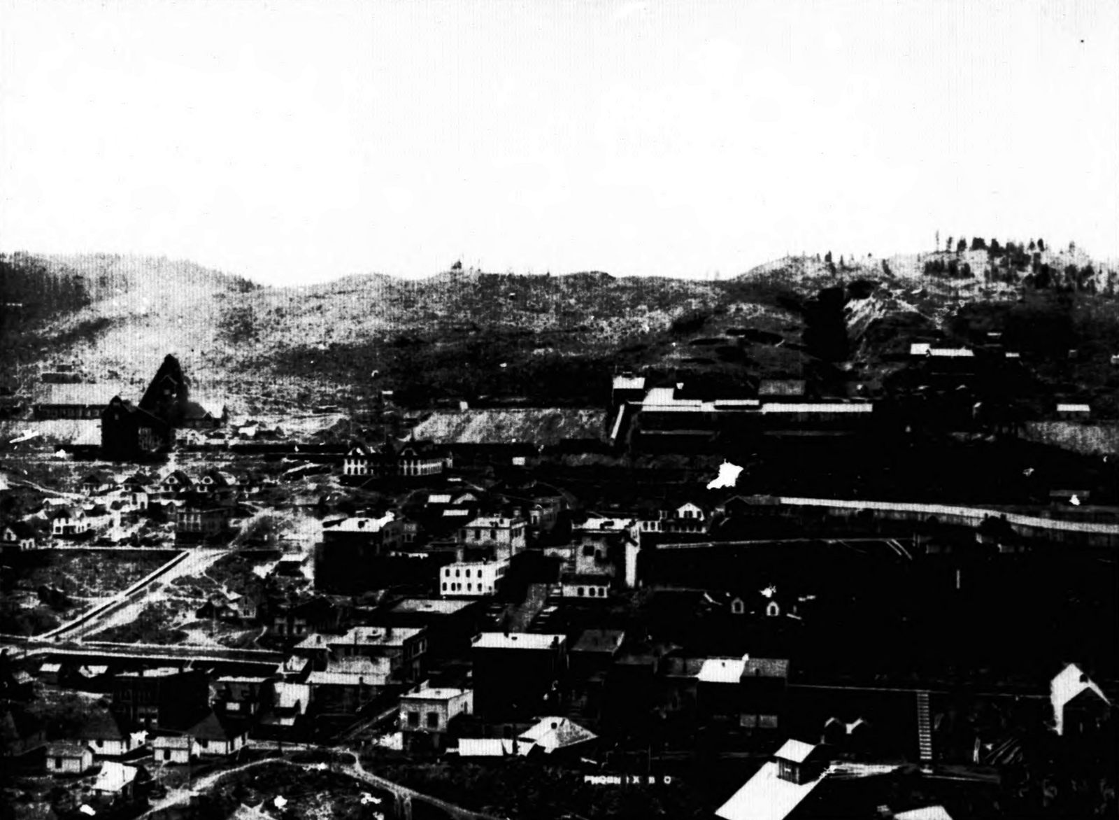 Phoenix, BC, looking south in 1908: the town below, the Granby headframes, ore houses and glory holes on the hill above, with PHOENIX B.C. lettered on the negative