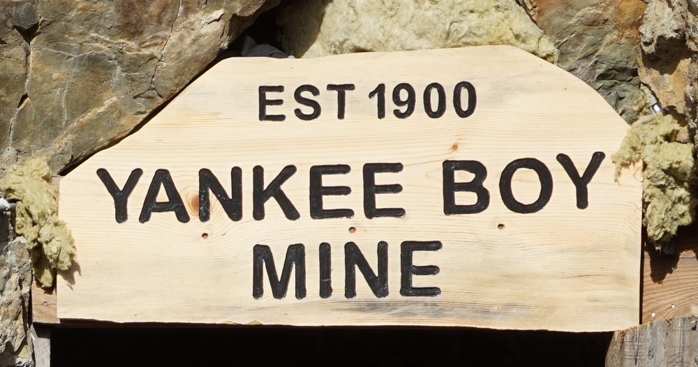 A carved wooden sign over the portal: Est 1900, Yankee Boy Mine